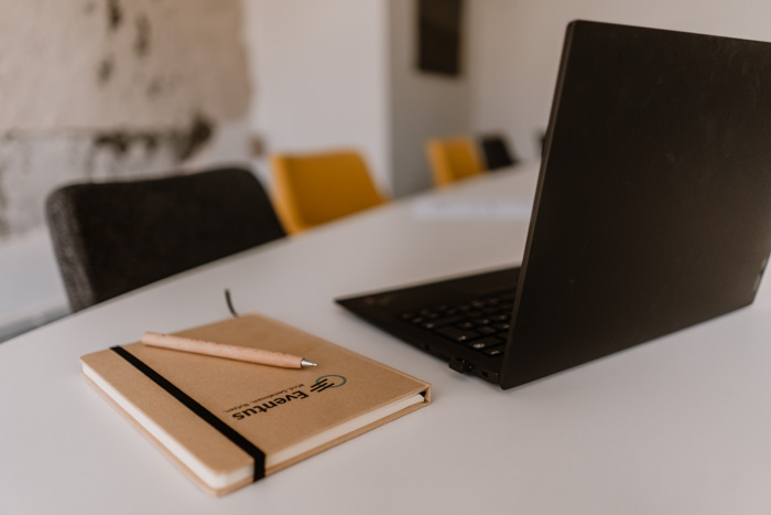 Frau steht auf einem Feld und hält ihre Hand so, dass es aussieht, als würde sie ein Windrad halten.